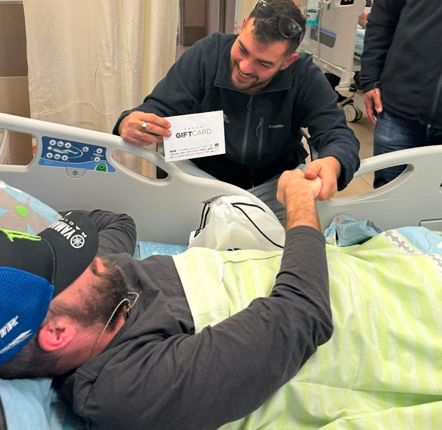Volunteer visiting wounded soldier lying in hospital bed